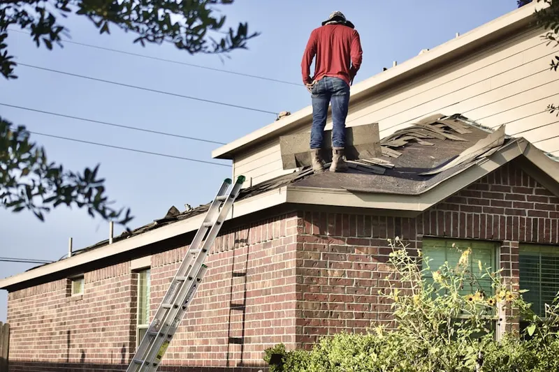 Professional roofer working on a residential roof in Plandome Heights